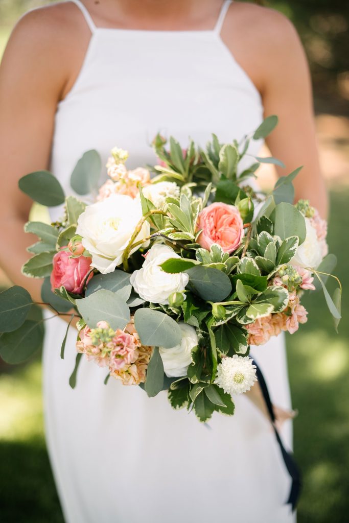 Fresh coral and white summer bridal bouquet of garden roses, Ranunculus, Scabious, Stock designed by Texas wedding florist Jessica Ormond Events. Picture by Amanda Scott Photograhy.