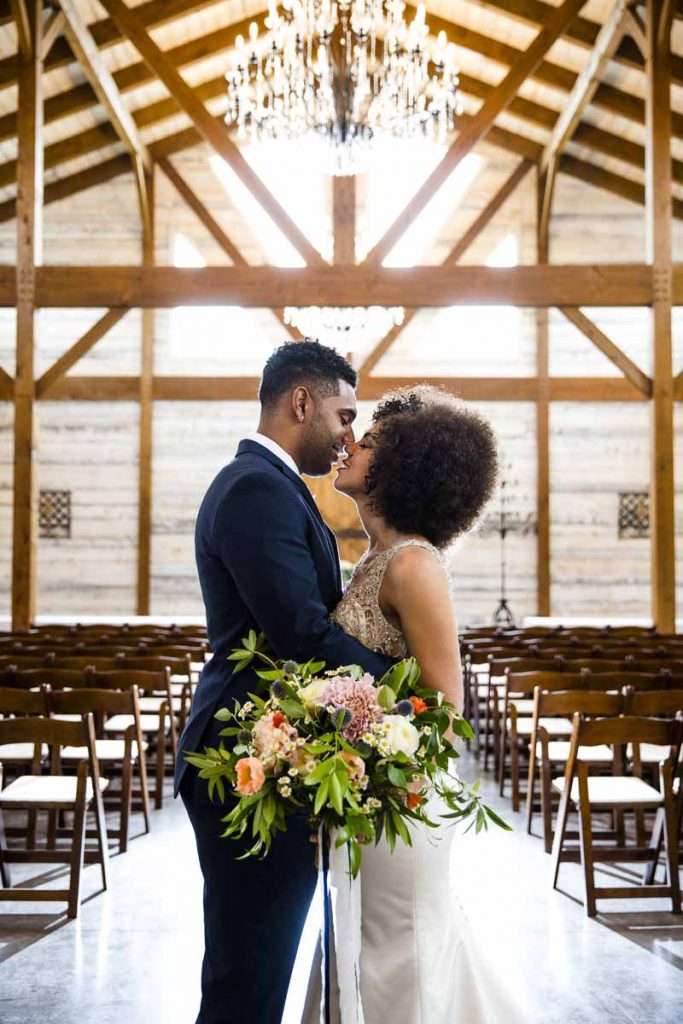 Bride and groom at Barn ceremony with garden bouquet. West Texas wedding florist Jessica Ormond Events. Caitlin and Ryan Photography.