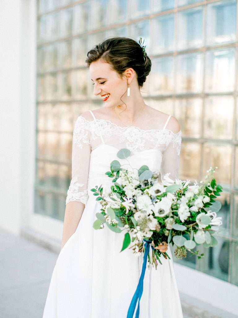 Elegant Texas bride in downtown Lubbock with textured bouquet in green and white.